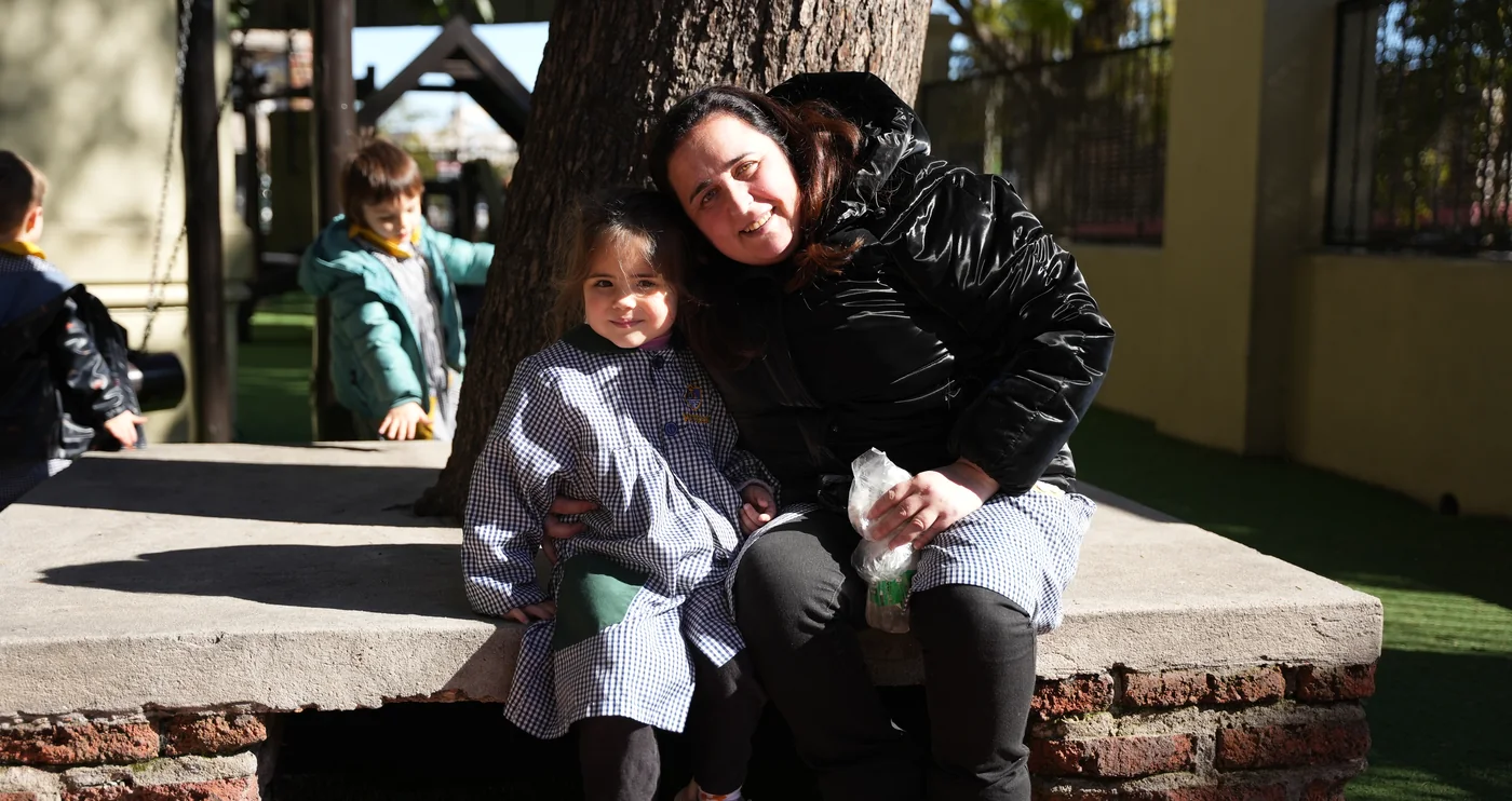 Una educadora y una niña de Inicial comparten un momento de cercanía en el patio de Maturana.