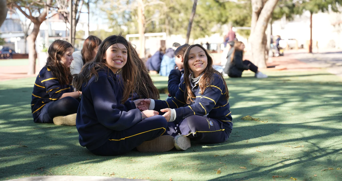 Dos estudiantes de Primaria sonríen mientras comparten una ronda en el patio de Maturana.