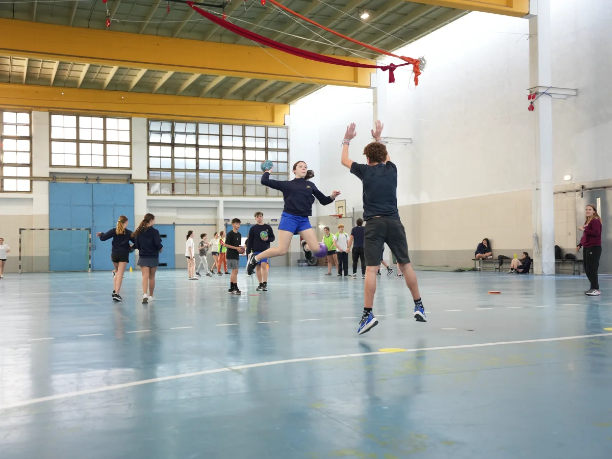 Estudiantes de Ciclo Básico juegan handball en la cancha cubierta.