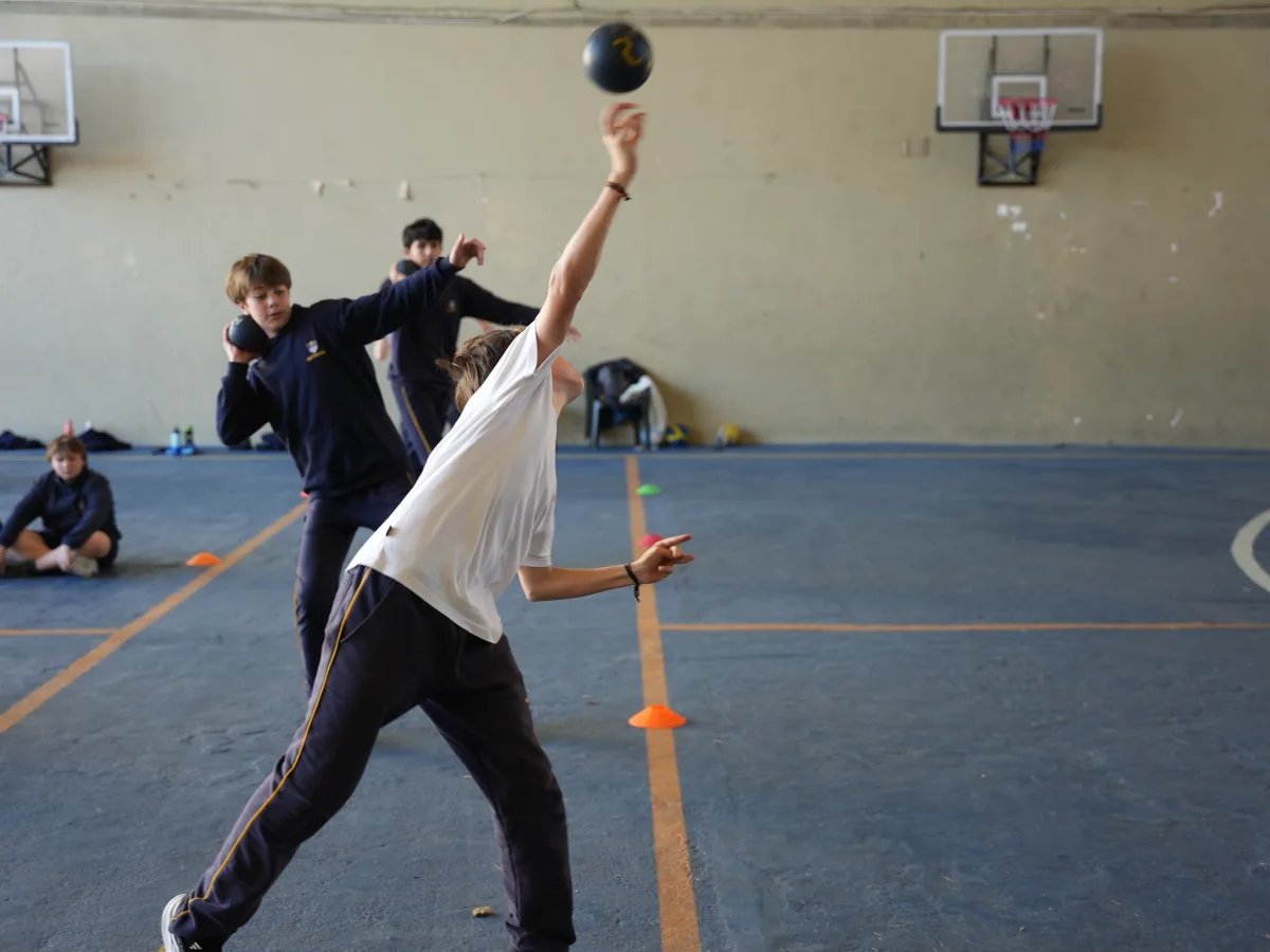 Un estudiante de Ciclo Básico practica lanzamiento durante una clase de atletismo.