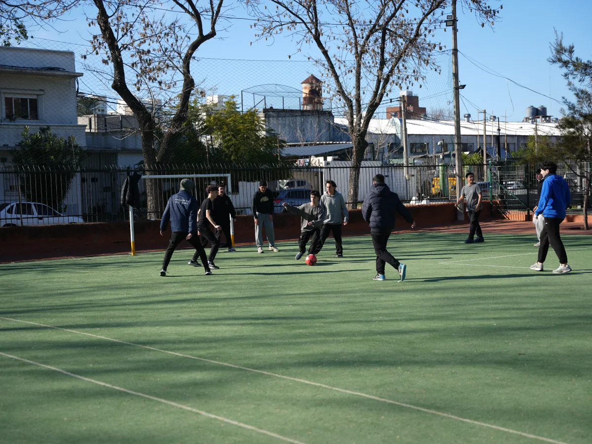 Estudiantes de Bachillerato juegan al fútbol en la cancha exterior.
