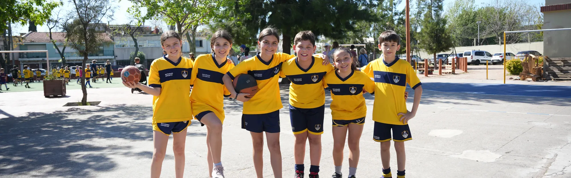 Grupo de estudiantes de Primaria con camisetas deportivas en el patio del colegio.