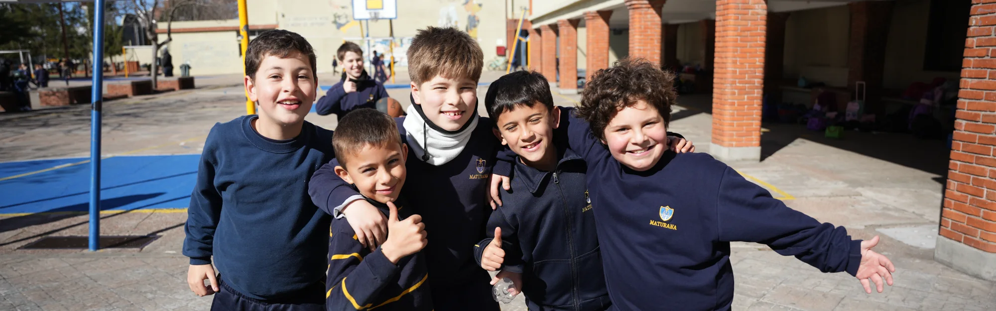 Estudiantes de Primaria sonriendo juntos en el patio del colegio.